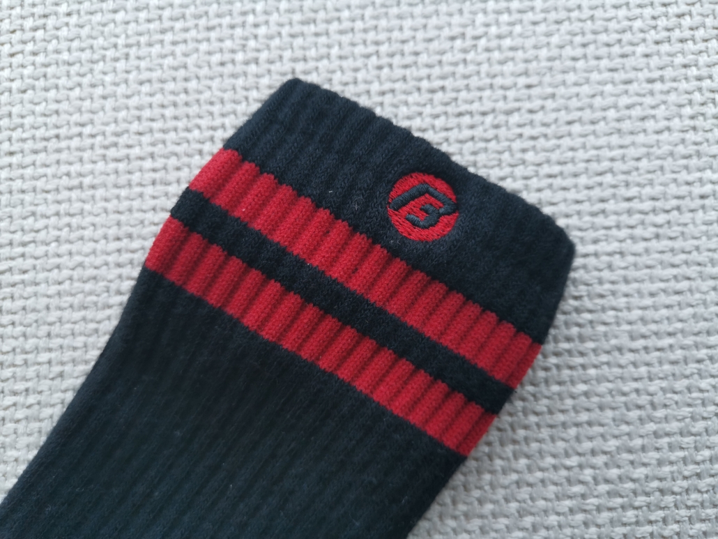 The black "B" embroidery logo on red circle, detailes of the black-red sports sock custom made.