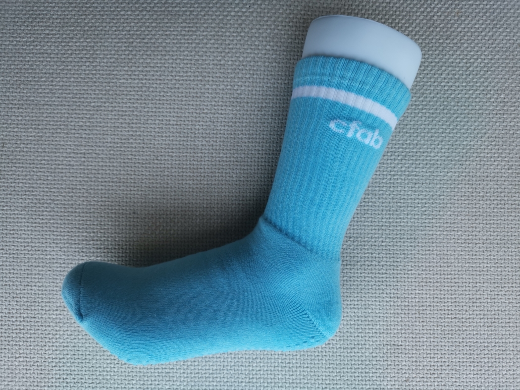 Custom gripping sock with logo, blue sock and white texts and stripe. Full-terry sock