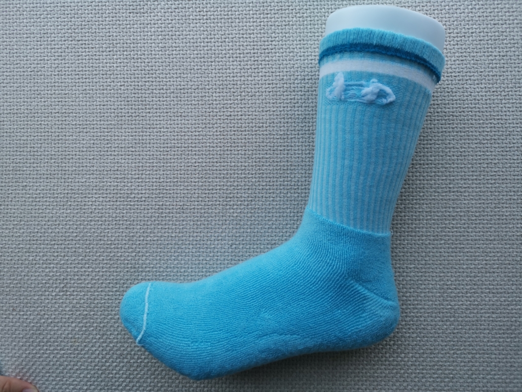 Inside view of a sports grip sock, full-terry cushion and knitted logo. Machine seam