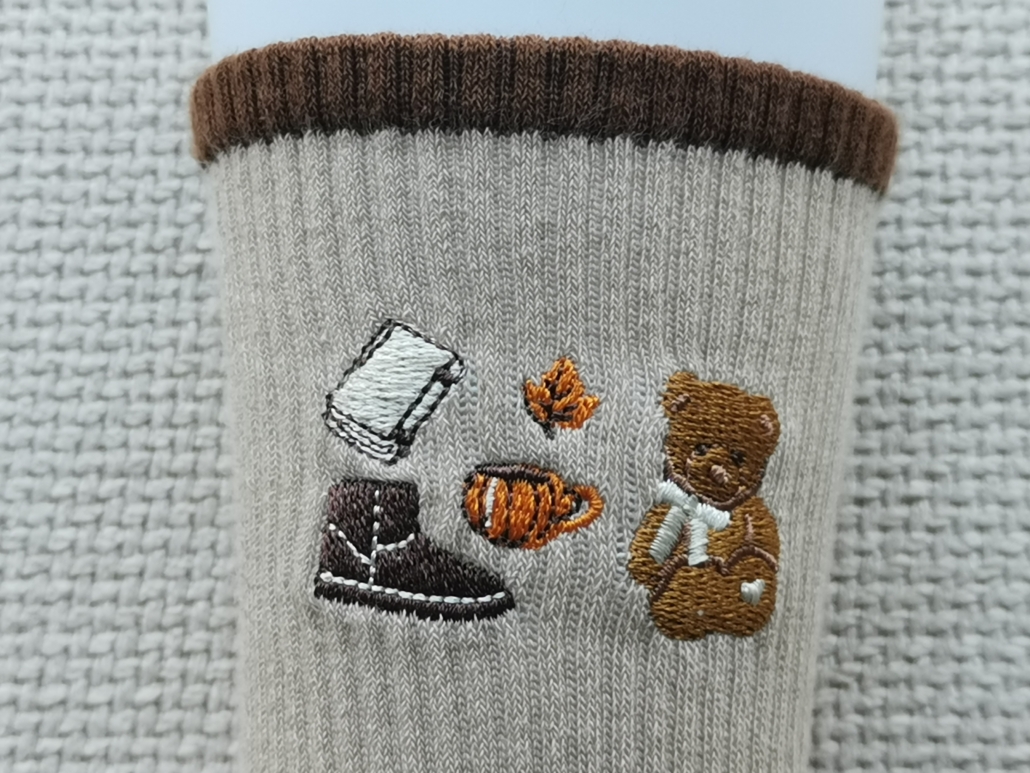 Large logo embroidery logo on socks big coverage close view books, shoes, cups and toys
