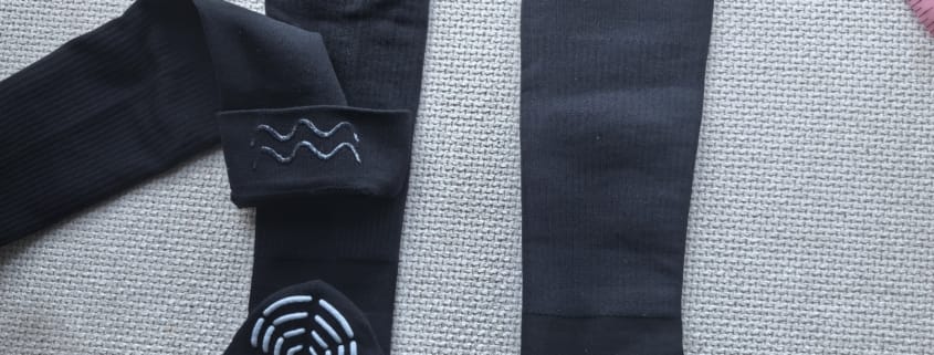 Black graduated compression knee-high sports socks with mesh upper, logo detail, and silicone grip on sole and inner cuff